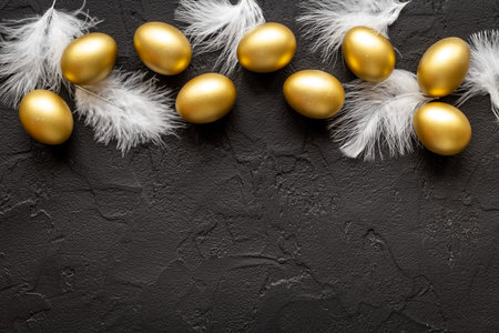 Golden Easter eggs with white feather. Easter decoration, top view