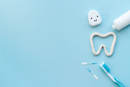 Oral care products flat lay. Toothbrushes with white tube of toothpaste and dental flossの写真素材