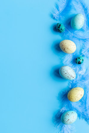 Flat lay of colorful Easter eggs and birds feather, top view
