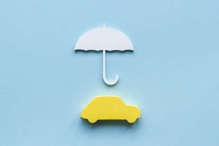 Buy car insurance concept. Car shape under umbrellaの写真素材