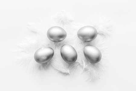 Silver Easter eggs with white feather. Easter decoration, top viewの写真素材