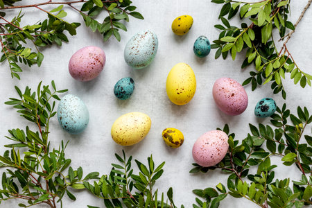 Easter decoration concept with eggs with spring branches and green leaves. Top view