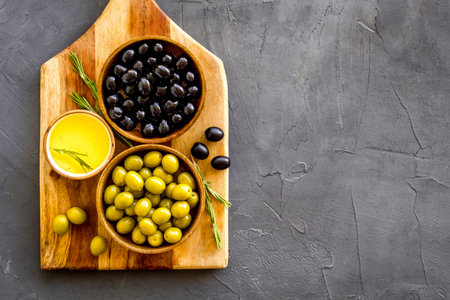 Top view of green and black olives in bowls with oilの写真素材