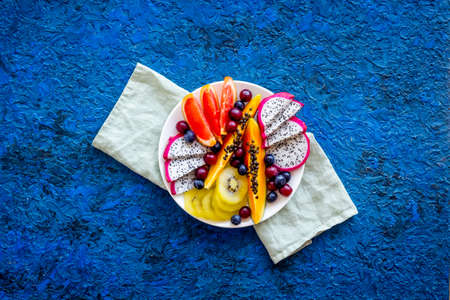 Group of tropical fruits in plate. Exotic breakfast with mango and dragon fruit. Top viewの写真素材