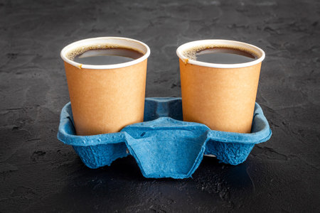Black coffee in paper cups with beans. Take away coffee background