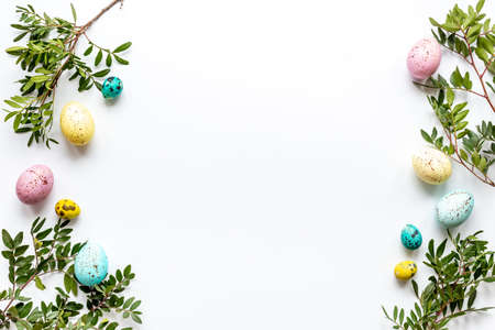 Happy Easter with colorful eggs and green branch, top view