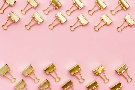 Frame of stationery golden paper binder clips top view. Office supplies patternの写真素材