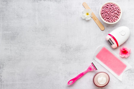 Epilation concept. Set of epilator with wax strips and razor, flat lay