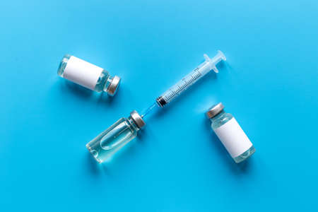 Coronavirus vaccine ampoules with syringe. Vaccination concept