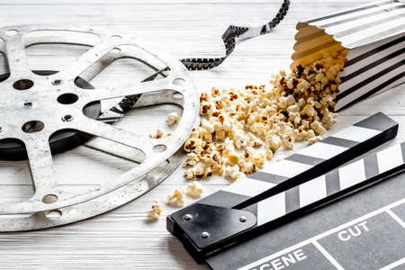 Cinema concept. Popcorn with film reel strip and clapper boardの写真素材