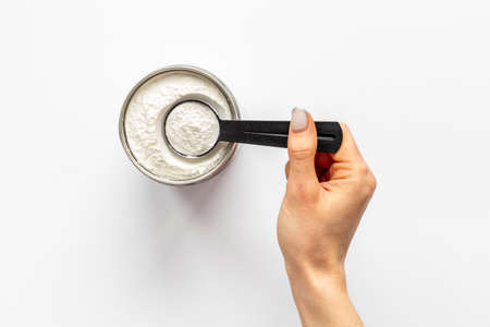 Hands holding scoop with whey protein. Sport nutrition