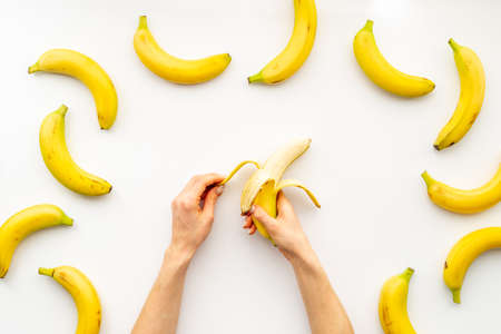 Hand holding peeled banana. Top viewの写真素材