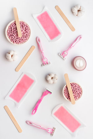 Pink epilator with wax strips and razor for removal of unwanted hair. Flat layの写真素材