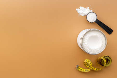 Whey protein in scoop and jar with tape measure. Sport nutritionの写真素材