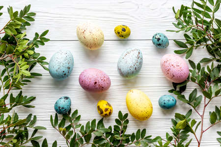 Happy Easter card with colorful eggs and green leaves. Overhead view