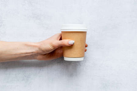 Paper cup with coffee in hand. Coffee take away concept