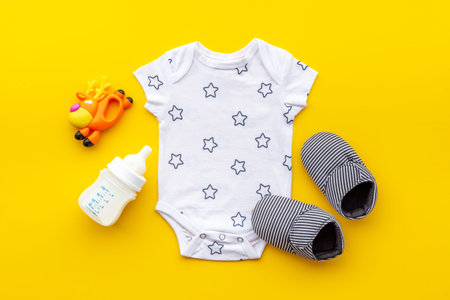 Baby accessories with bodysuit and shoes. Flat lay