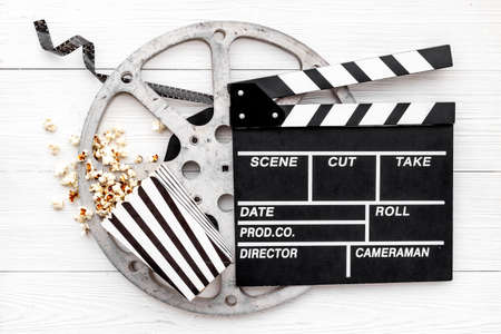 Layout of film reel with popcorn and clapperboard. Cinema concept