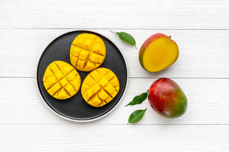 Plate of mango fruits and mango cubes. Tropical breakfast. Top viewの写真素材