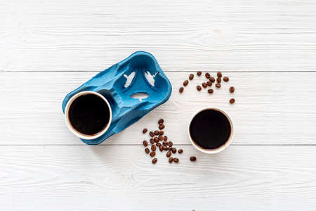 Flat lay of black coffee in paper cups with beans