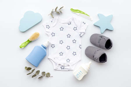 Flat lay of baby boy bodysuit with malk bottle.の写真素材