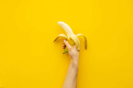 Hand holding peeled banana. Top viewの写真素材