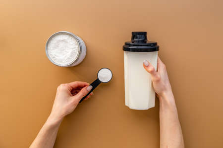 Hands holding protein powder in scoop. Sport nutritionの写真素材