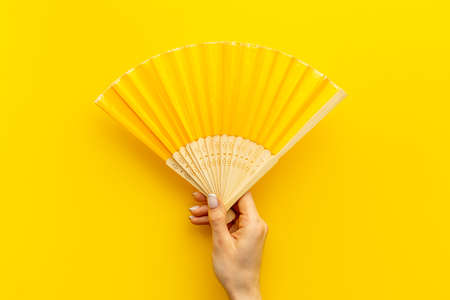 Hand holding hand fan made of bamboo and paperの写真素材