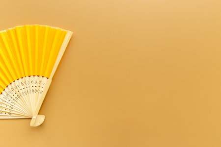 Yellow golden hand fan made of bamboo and paper. Top viewの写真素材