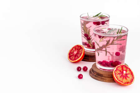 Glasses of cranberry lemonade and red oranges with rosemaryの写真素材