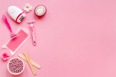 Cosmetics and means for epilation with flowers on pink background, flat lay