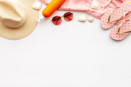 Flat lay of summer beach accessories isolated on white. Sraw hat with sunglasses and flip flopsの写真素材