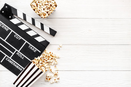 Film reel with popcorn and clapperboard. Cinema concept