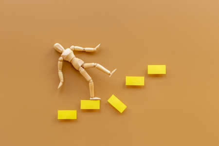 Man mannequin figure falling down from stairs. Accident failure and fiasco in business conceptの写真素材