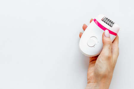 White epilator in female hand for hair removal and depilatory. Top viewの写真素材