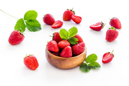 Close up of red strawberry in wooden bowl with leavesの写真素材