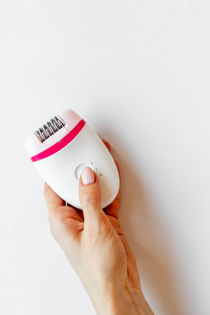 White epilator in female hand for hair removal and depilatory. Top view