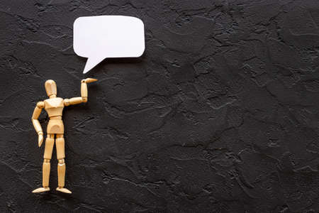 Wooden man figure presenting and showing on speech bubble bannerの写真素材
