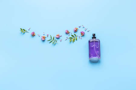 Top view of perfume bottle with flowers and leavesの写真素材