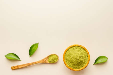 Henna powder in wooden bowl with green leaves. Herbal natural hair dyeの写真素材