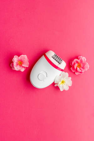 Top view of white epilator with flowers for hair removalの写真素材