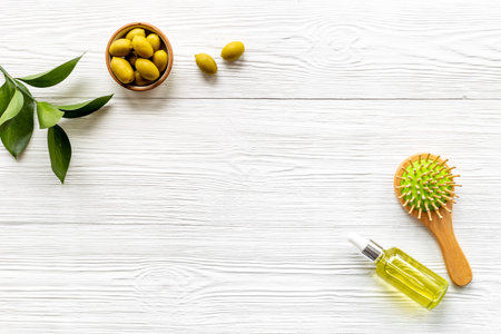 Olive oil for hair treatment with wooden hair brush