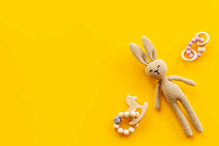 Knitted baby toy rabbit for newborn with wooden toys, top view.の写真素材