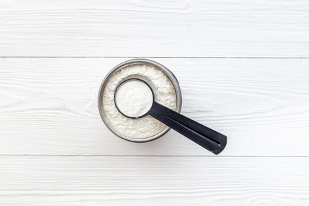 Sport nutrition - whey protein powder in scoop and jar.
