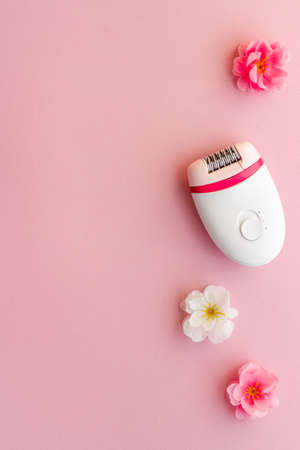 Top view of white epilator with flowers for hair removalの写真素材