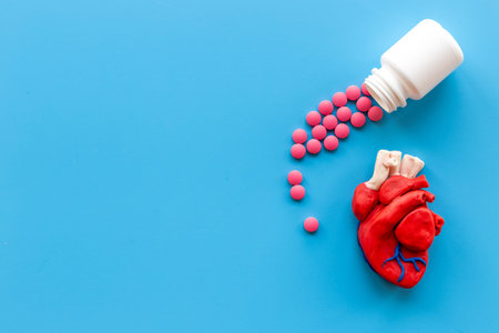 Human heart model with pills top view. Cardioigy and heart health concept