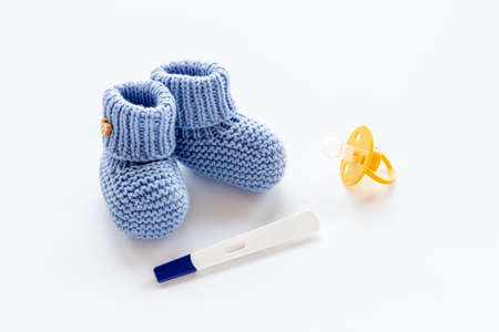 Baby boy booties with pregnancy test. Morherhood and pregnancy conceptの写真素材