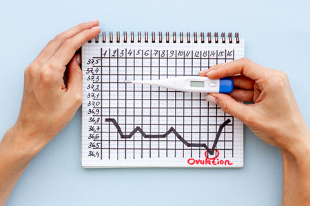 Basal temperature calendar with hands holding ovulation home test