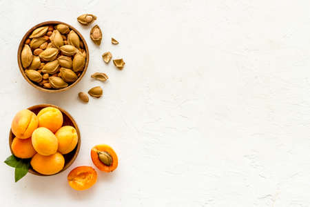 Wooden bowls of apricots and apricot kernel almond, top viewの写真素材