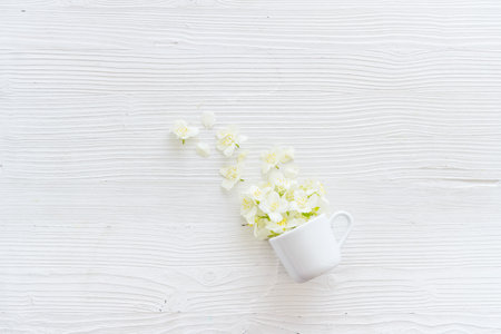 Jasmine flowers flying into a cup. Herbal tea conceptの写真素材